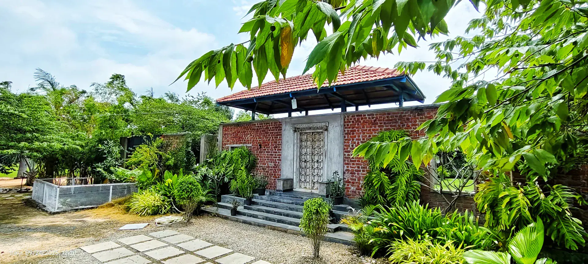 Brick garden entrance surrounded by tropical planting