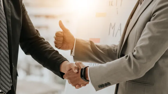 Business handshake with approval gesture